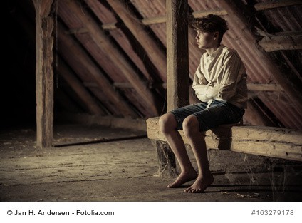 Soziale Angst. Auf dem Bild ist ein Junge zu sehen. Er sitzt ängstlich auf einem Balken in einem großen, schwach beleuchteten Dachboden.